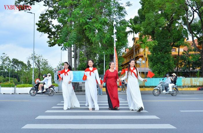 Nhiều người chọn trang phục áo dài truyền thống, mang theo cờ Tổ quốc tới chụp ảnh kỷ niệm nhân dịp 81 năm Ngày Quốc khánh 2/9.