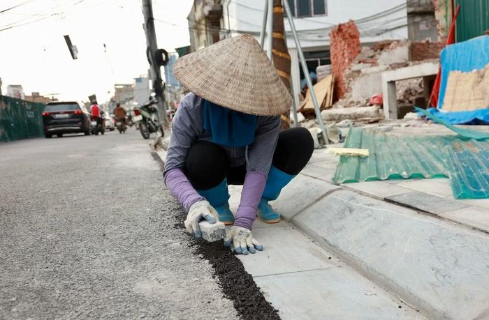  Các công nhân đang khẩn trương tăng ca lát vỉa hè, thảm nhựa tại một số vị trí. 