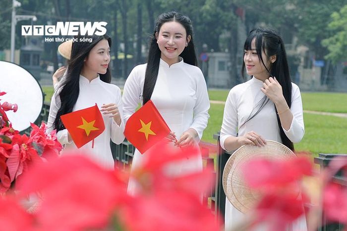 Các nhóm bạn trẻ lần lượt tìm vị trí, chờ đến lượt để có những bức ảnh kỷ niệm giữa không gian rực rỡ cờ hoa.