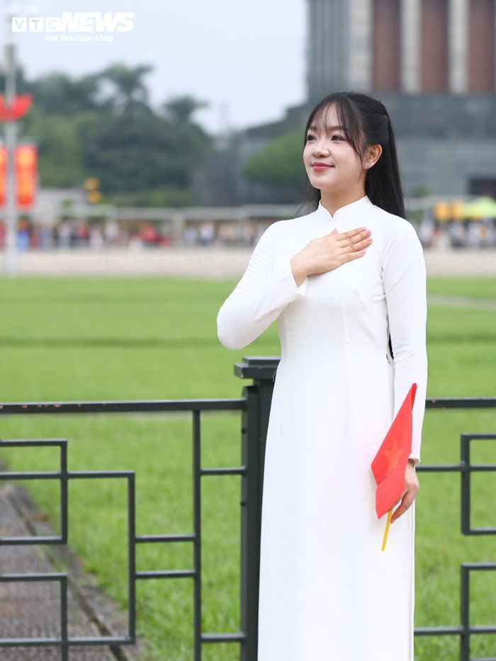 Một số thiếu nữ lựa chọn áo dài truyền thống, mang theo cờ Tổ quốc để chụp ảnh.