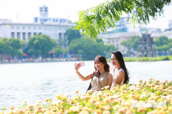 Bên hồ Gươm thơ mộng, muôn sắc hoa rực rỡ, các nàng thơ thỏa sức tạo dáng, check-in để có cho mình những bức hình đẹp lung linh.