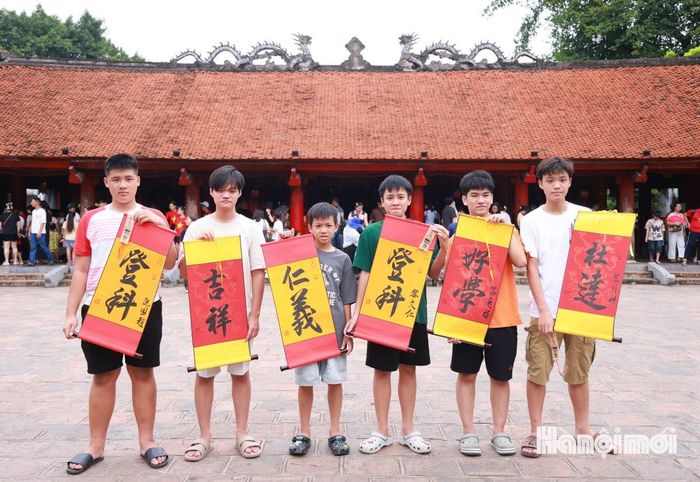Một nhóm em nhỏ được phụ huynh đưa từ Quảng Trị ra thăm quan, xin chữ tại Văn Miếu.