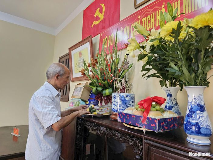 Ông Công Ngọc Dũng sửa soạn ban thờ Chủ tịch Hồ Chí Minh tại ngôi nhà lưu niệm nhân dịp Quốc khánh 2/9. Ảnh: Tuệ Lâm