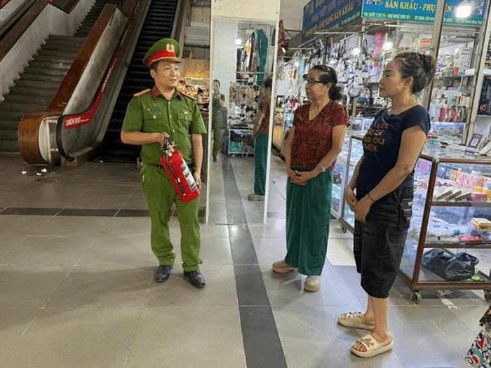 Cảnh sát tuyên truyền kết hợp hướng dẫn sử dụng phương tiện chữa cháy tại chỗ cho các tiểu thương tại Chợ Nghệ Sơn Tây – phường Sơn Tây. Ảnh: Công an thành phố Hà Nội 