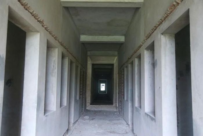 Một dãy phòng đã được trát vữa nhưng vẫn trong tình trạng bỏ dở. Nhiều mảng tường bên trong công trình vẫn để nguyên phần gạch xây, cho thấy quá trình hoàn thiện đã dừng lại từ nhiều năm trước.