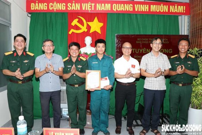 Ông Nguyễn Quốc Bảo, Bí thư Đảng ủy phường Ba Ngòi (áo thun) cùng lãnh đạo địa phương, Ban CHQS phường động viên, tặng quà cho Phong trước khi nhập học. Ảnh: Duy Ngọc.