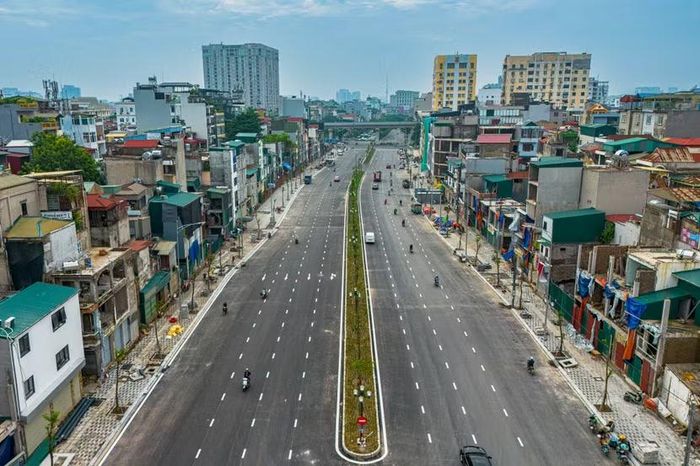 Mặt đường thảm nhựa đen bóng chia 8 làn xe cùng dải phân cách giữa phủ thảm cỏ xanh mướt nhìn thẳng từ trên cao xuống đoạn qua phường Giảng Võ.