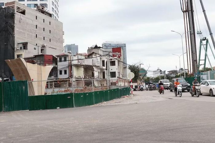 Trụ cầu vượt đã đổ bê tông vươn cao cạnh máy khoan cọc nhồi và khu vực nhà dân đang được tháo dỡ khẩn trương để hoàn thành toàn bộ mặt bằng dự án.