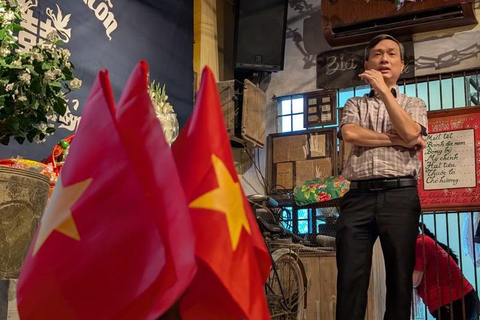Bảng niêm yết phân phối hàng Tết năm Nhâm Tuất 1982 bên cạnh cờ Tổ quốc – minh chứng cho sự công bằng, chắt chiu của thời kỳ phân phối theo định mức.