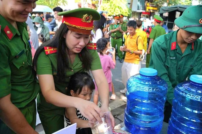 Dưới nắng hè, những lưng áo đẫm mồ hôi vẫn tiếp tục di chuyển giữa dòng người. Một tay làm nhiệm vụ, một tay trao chai nước; vừa điều tiết giao thông, vừa tận tình chỉ dẫn.