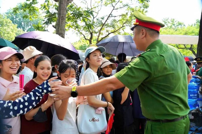 Sau nhiều giờ làm nhiệm vụ ngoài trời, lưng áo của người cán bộ Công an đã ướt đẫm mồ hôi, nhưng anh vẫn liên tục di chuyển, hướng dẫn và hỗ trợ người dân.