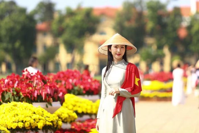 Một khoảnh khắc duyên dáng của thiếu nữ Hà Nội trong tà áo dài truyền thống và lá cờ đỏ sao vàng