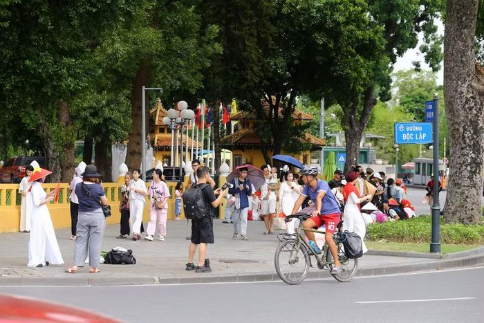 Đường Độc Lập, phía trước Quảng trường Ba Đình đông đúc người dân, du khách mọi lứa tuổi đổ về chụp ảnh