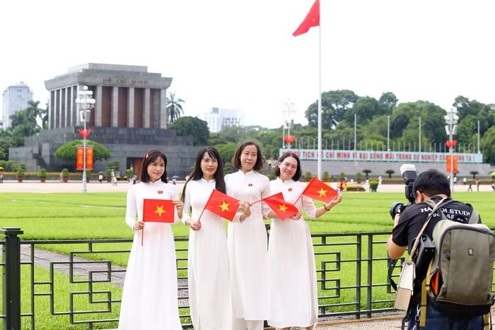 Những tà áo dài thướt tha hòa cùng sắc đỏ của cờ Tổ quốc tạo nên hình ảnh đẹp bên Lăng Chủ tịch Hồ Chí Minh