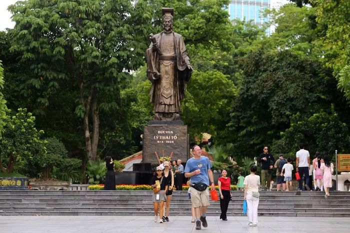 Du khách nước ngoài thích thú khám phá không gian Tượng đài Lý Thái Tổ, hòa cùng không khí vui tươi của người dân Thủ đô
