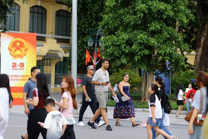 Những vị khách nước ngoài hòa mình vào dòng người Việt Nam đang vui chơi, tham quan quanh Hồ Gươm