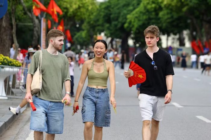 Những chiếc quạt giấy đỏ sao vàng trở thành món phụ kiện đặc biệt, theo chân du khách quốc tế khám phá Hồ Gươm dịp Quốc khánh