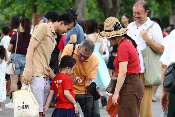 Khoảnh khắc thân thiện giữa du khách quốc tế và em nhỏ khi cùng xem lại những hình ảnh vừa được ghi lại tại Hồ Gươm