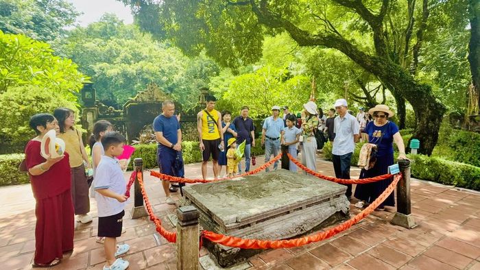 Du khách khám phá long sàng - bảo vật quốc gia trong di tích cố đô Hoa Lư. Ảnh: Đình Minh