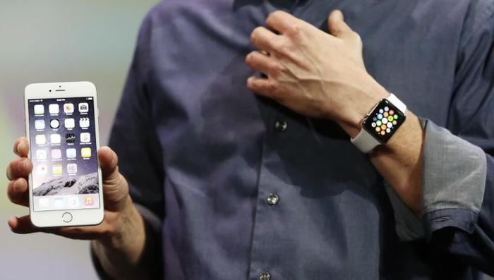 Tim Cook cùng dòng sản phẩm AirPods và Apple Watch. Ảnh: Shutterstock/Reuters.