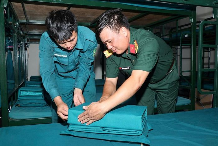 Thượng tá Nguyễn Thành Chơn, Chỉ huy trưởng Ban CHQS phường Ba Ngòi hướng dẫn Đinh Quốc Phong xếp nội vụ