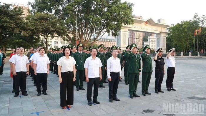 Các đại biểu và cán bộ, chiến sĩ thực hiện nghi thức chào cờ tại Cửa khẩu quốc tế Lào Cai. (Ảnh: CÔNG HẢI)