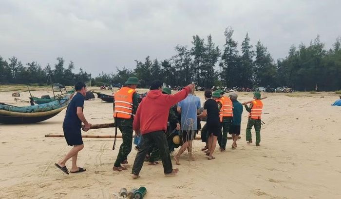 Đồn Biên phòng Cửa khẩu cảng Cửa Việt hỗ trợ ngư dân đưa ngư lưới cụ vào bờ. (Ảnh: H.M)