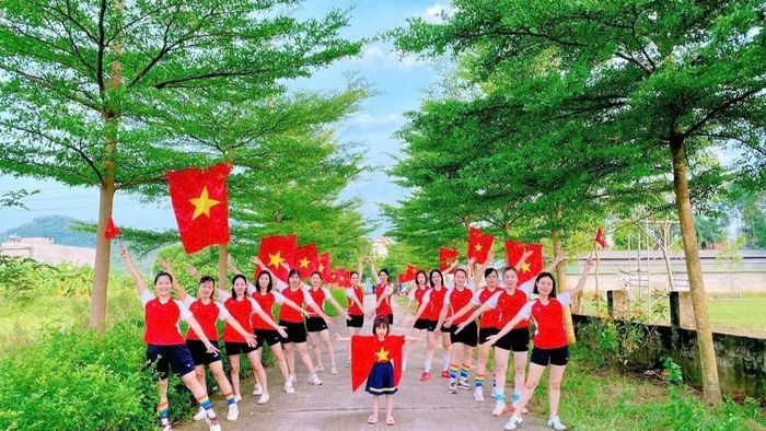 Chị em phụ nữ xã Quang Trung chụp ảnh kỷ niệm bên đường cờ. ( Ảnh: CTV)