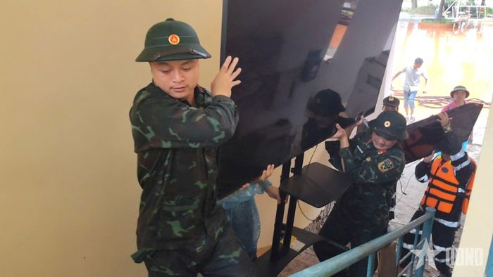 Hỗ trợ sơ tán tài sản ở các khu vực ngập lụt. Ảnh: NGUYỄN THU