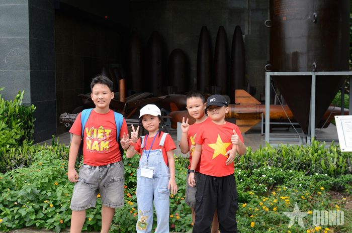 Các em nhỏ trong trang phục mang sắc đỏ sao vàng theo gia đình đến tham quan, tìm hiểu lịch sử.