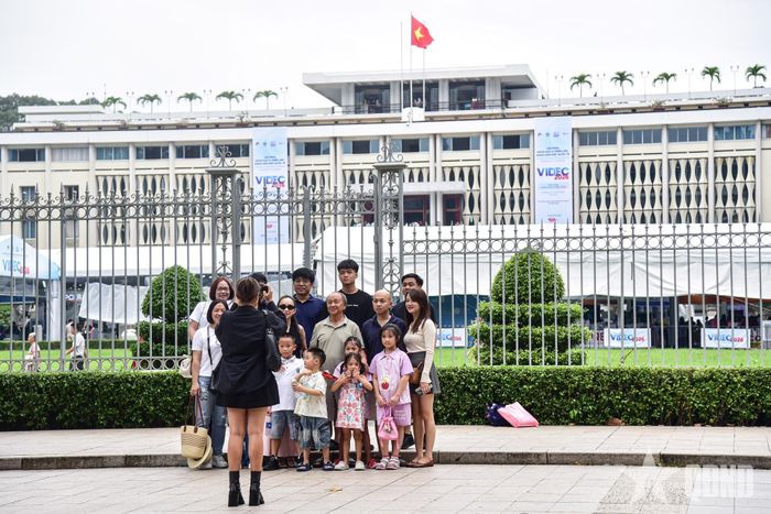Đại gia đình nhiều thế hệ chụp ảnh lưu niệm trước Dinh Độc Lập. 