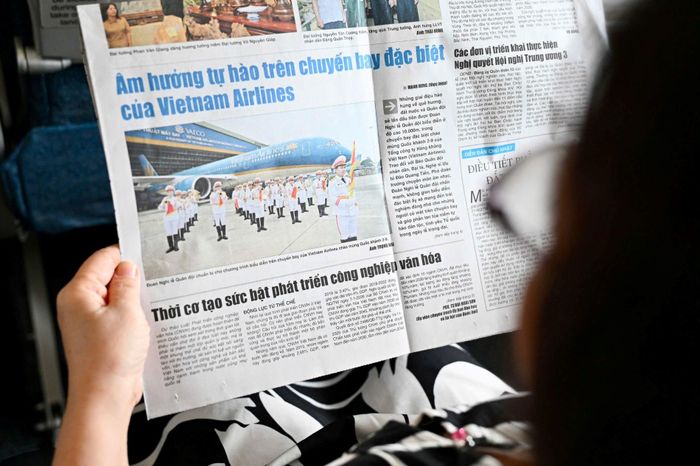  Hành khách đọc Báo Quân đội nhân dân trên chuyến bay của Vietnam Airlines.