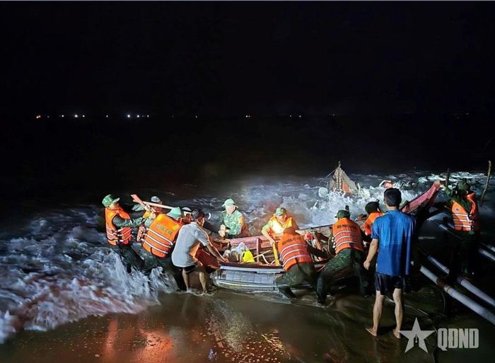 Cán bộ, chiến sĩ Đồn Biên phòng Hải An (Ban chỉ huy BĐBP tỉnh Quảng Trị) xuyên đêm hỗ trợ ngư dân đưa 4 thuyền đánh cá và ngư lưới cụ về nơi an toàn. Ảnh: HOÀI NAM