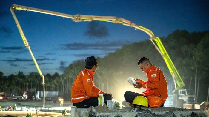 Công nhân thi công ca đêm tranh thủ nghỉ ngơi dùng cơm tại công trường. Ảnh: T.Đ.C.