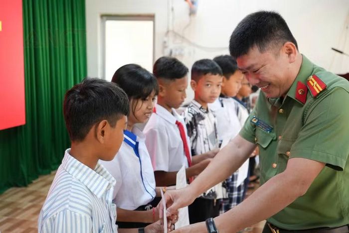 Thiếu tá Huỳnh Phước Vui trao giấy báo nhập học cho các học sinh.