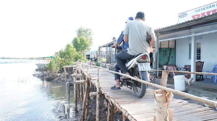 Đường bị sạt lở, người dân đóng góp tiền làm cầu tạm.