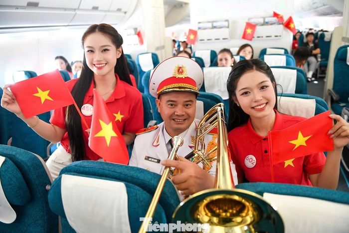 Các thí sinh hòa giọng hát, vẫy cờ, vỗ tay cổ vũ cán bộ, chiến sĩ Đoàn Nghi lễ Quân đội.