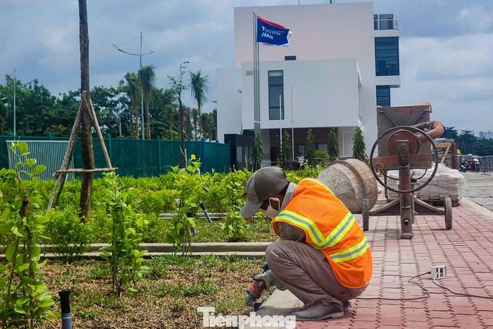 Công nhân tất bật hoàn thiện các hạng mục tại cống ngăn triều Tân Thuận, từ sơn sửa, chỉnh trang lan can, nhà điều hành đến lát vỉa hè, chăm sóc cây xanh.