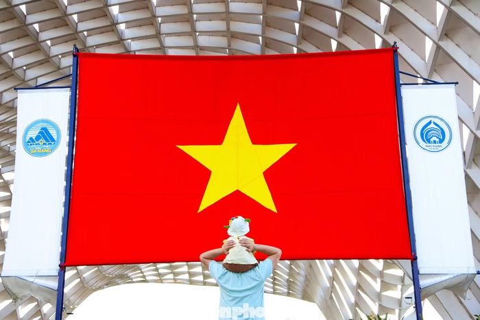 Cùng gia đình dạo phố dọc sông Hàn, anh Nguyễn Văn Mạnh (34 tuổi, phường Sơn Trà) tranh thủ chụp vài tấm ảnh lưu niệm bên lá đại kỳ được treo trang trọng ở Công viên APEC phường Hải Châu.