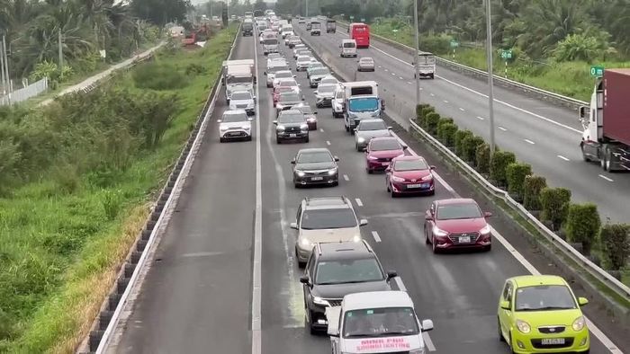 Xe từ miền Tây về TPHCM ùn ứ, CSGT mở làn khẩn cấp để giảm kẹt xe.