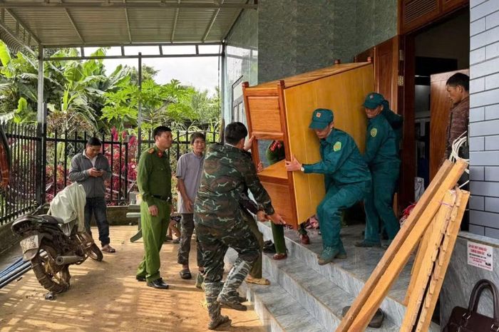Lực lượng chức năng hỗ trợ người dân di dời tài sản khỏi khu vực có nguy cơ sạt lở.
