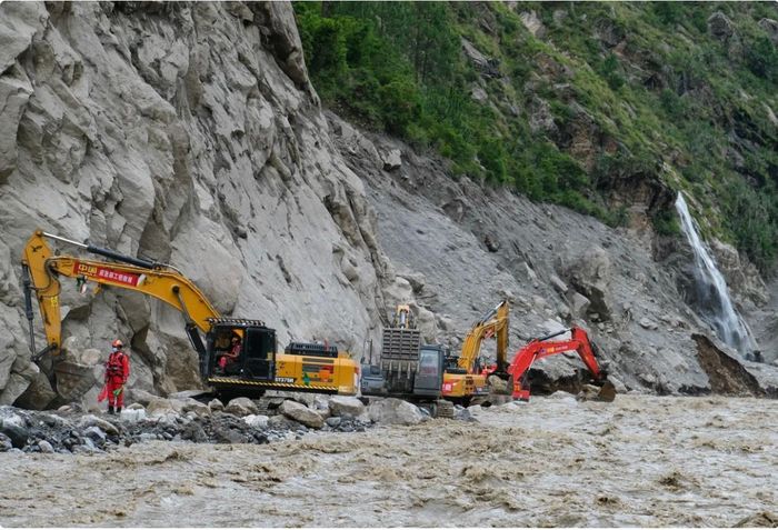 Các máy xúc hạng nặng đang dọn đường dẫn tới cửa khẩu Gyirong tại khu vực bị ảnh hưởng bởi sạt lở đất. Ảnh: China News Service.