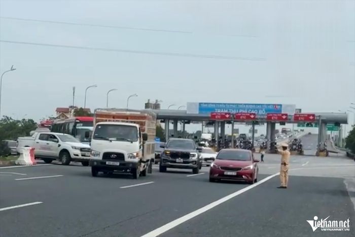 CSGT hướng dẫn ô tô đi vào làn ngược chiều tại khu vực Trạm thu phí Cao Bồ. Ảnh: Đình Hiếu