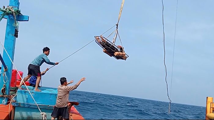 Dùng cẩu đưa người bị thương lên nhà giàn cấp cứu