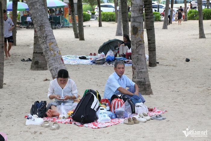 Nhiều gia đình chọn ngồi hóng mát trên bãi cát