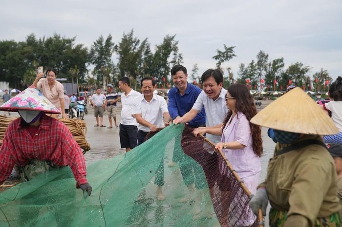 Giám đốc Sở VH-TT-DL Thanh Hóa Lê Văn Trung (áo xanh) cùng bí thư và chủ tịch phường Nam Sầm Sơn tham gia kéo lưới cùng ngư dân và khách du lịch