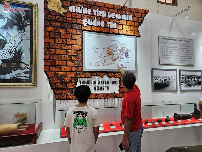 Người ông giới thiệu cho cháu những bức ảnh trong Nhà trưng bày các kỷ vật chiến tranh ở Vĩ tuyến 17 năm xưa.