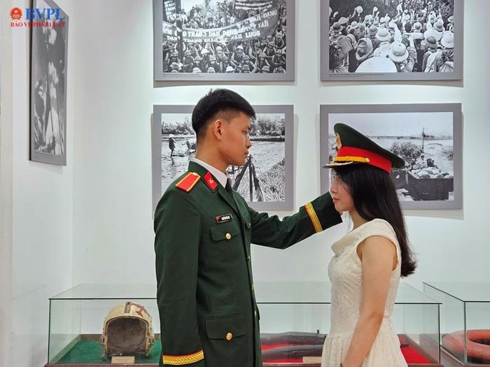 Người chiến sỹ đội mũ lên đầu bạn gái khi tham quan những kỷ vật chiến tranh.