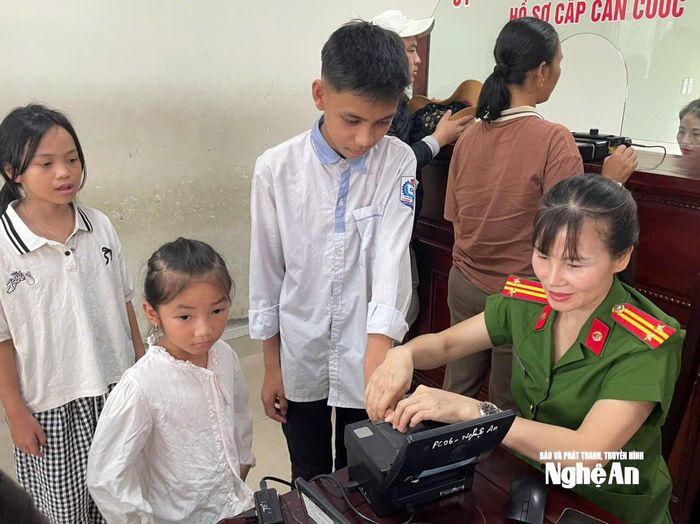 Cán bộ tại Bộ phận một cửa Công an tỉnh lăn tay để làm căn cước cho các em nhỏ. Ảnh tư liệu: P.V