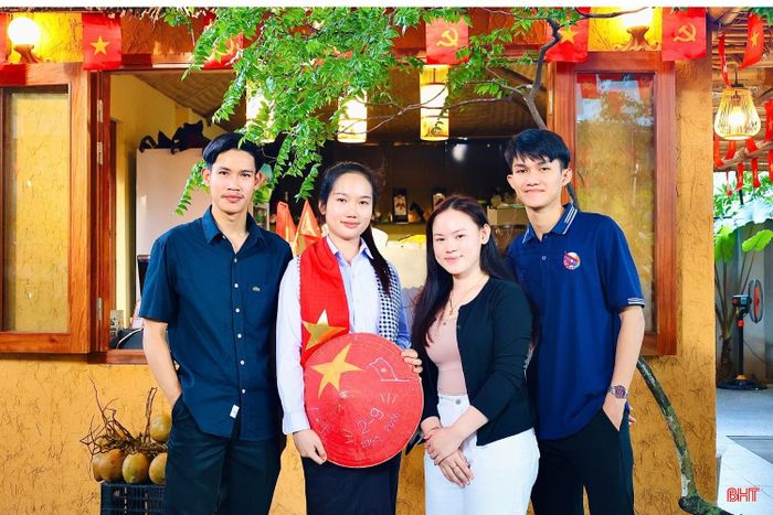 Em Atsomphanh Khamla (ngoài cùng bên phải) cùng các bạn chụp ảnh lưu niệm trong không gian rực rỡ cờ đỏ sao vàng tại Hà Tĩnh.
